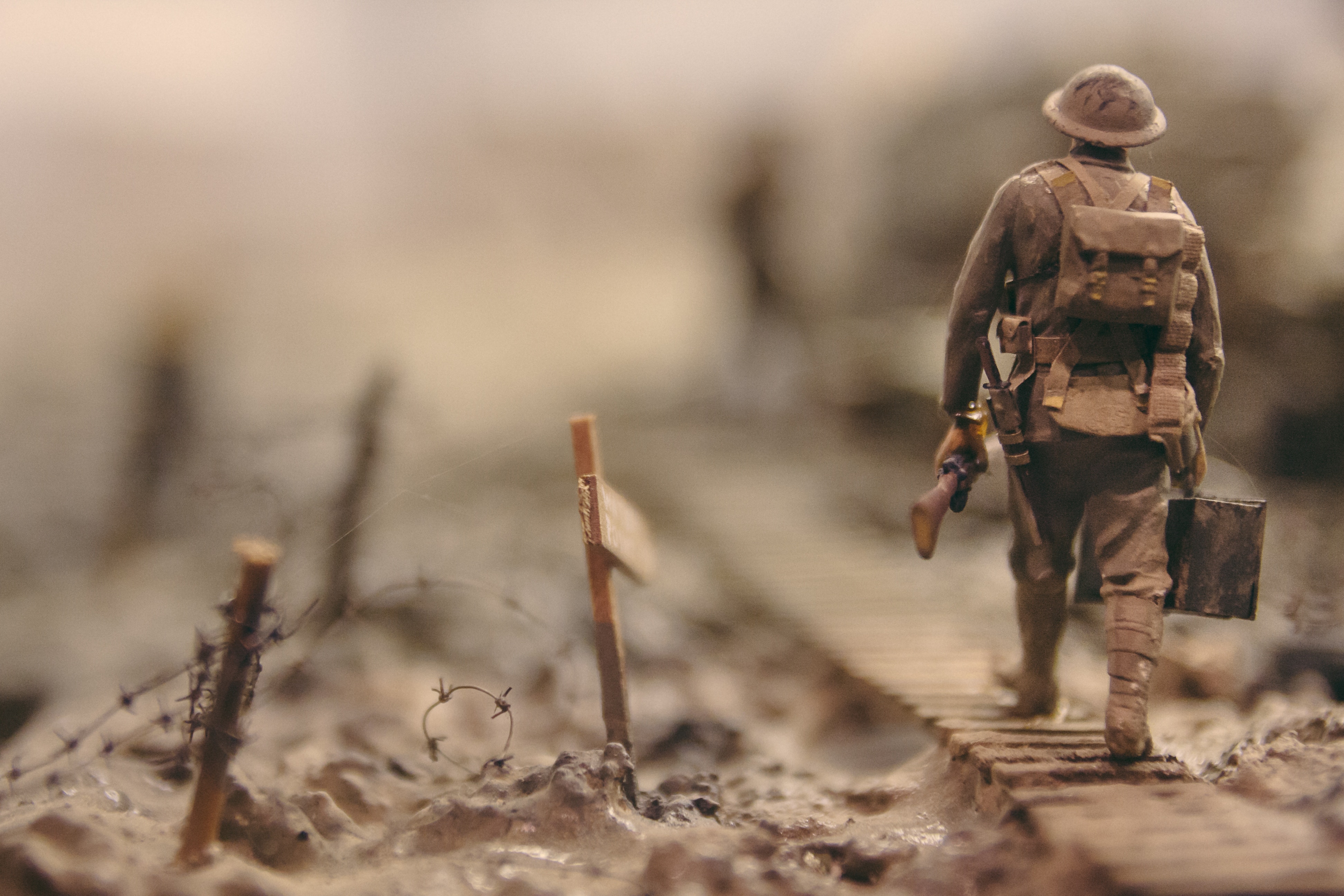 soldier walking on wooden pathway surrounded with barbwire selective focus photography © Photo by Stijn Swinnen on Unsplash