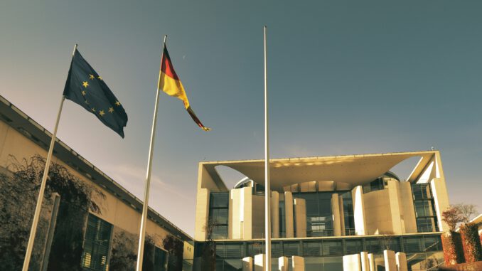 Vor dem Kanzleramt wehen Deutschland- und Europaflagge. Doch nach dem Wahldebakel in Sachsen-Anhalt scheint Berlin die soziale und politische Warnung weiter zu überhören. Foto: detait auf Unsplash
